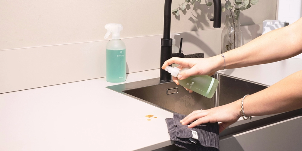 personne nettoyant sa cuisine avec un chiffon